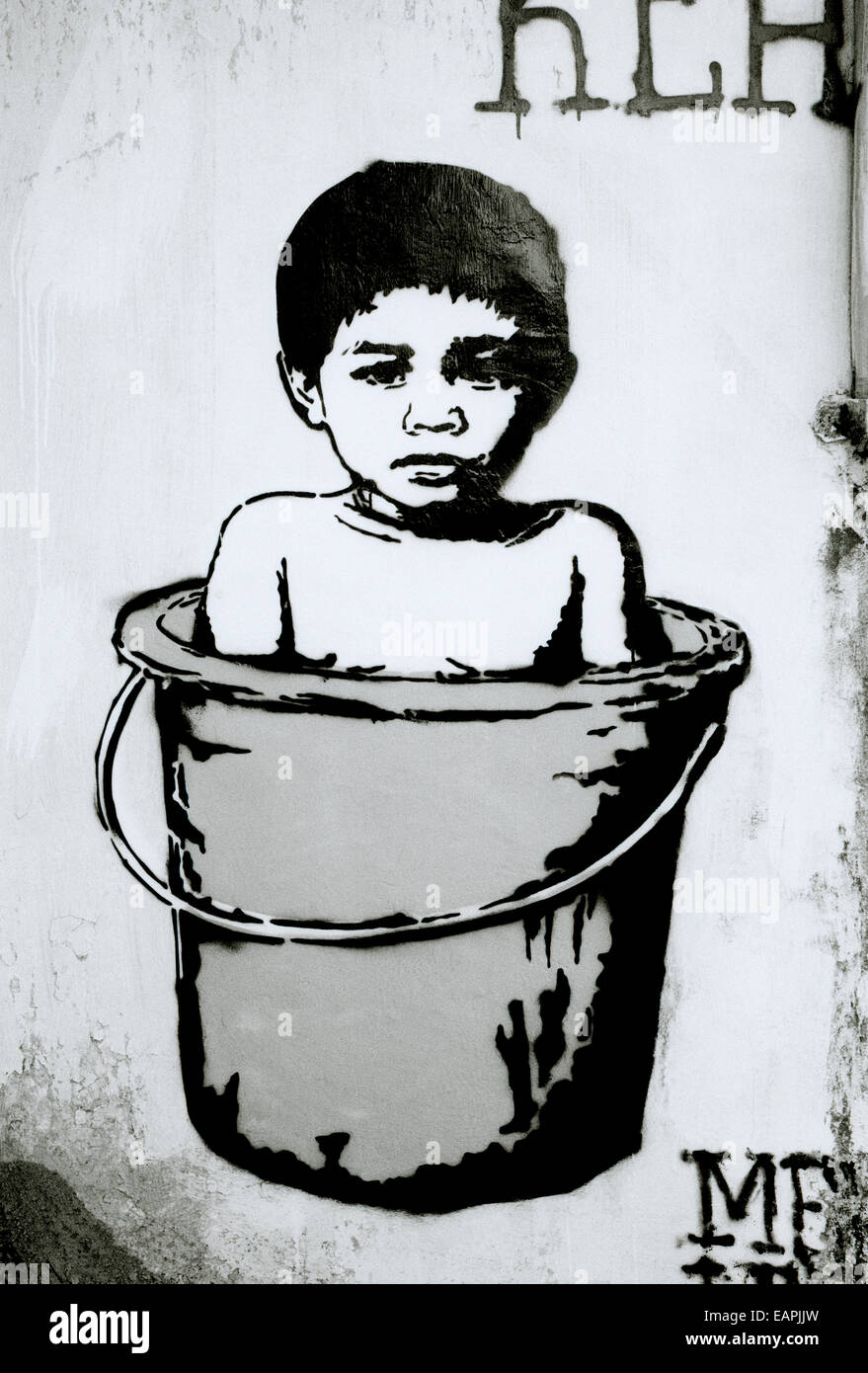 Banksy style surreal urban street graffiti art in Yogyakarta in Java in Indonesia in Southeast Asia Far East. Baby Child Childhood Travel Conceptual Stock Photo