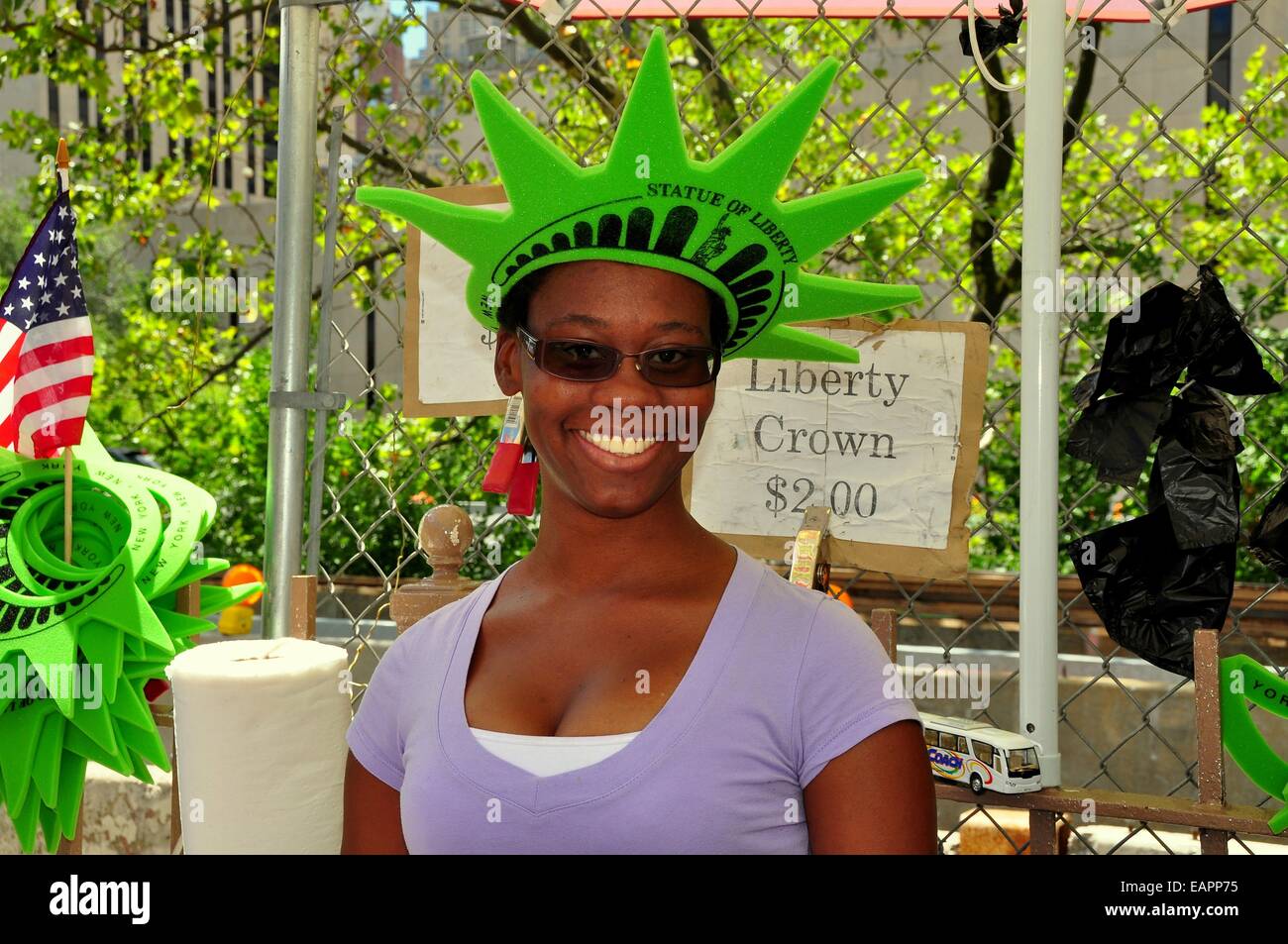 NYC:  Smiling woman wearing a Statue of Liberty foam rubber souvenir crown that she sells on the Brooklyn Bridge Stock Photo