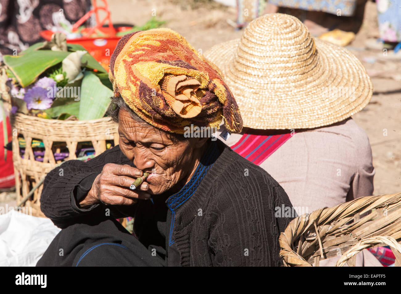 Elderly woman smoking at vegetable market at Inle Lake,Burma,Myanmar,South East Asia, Asia, Stock Photo