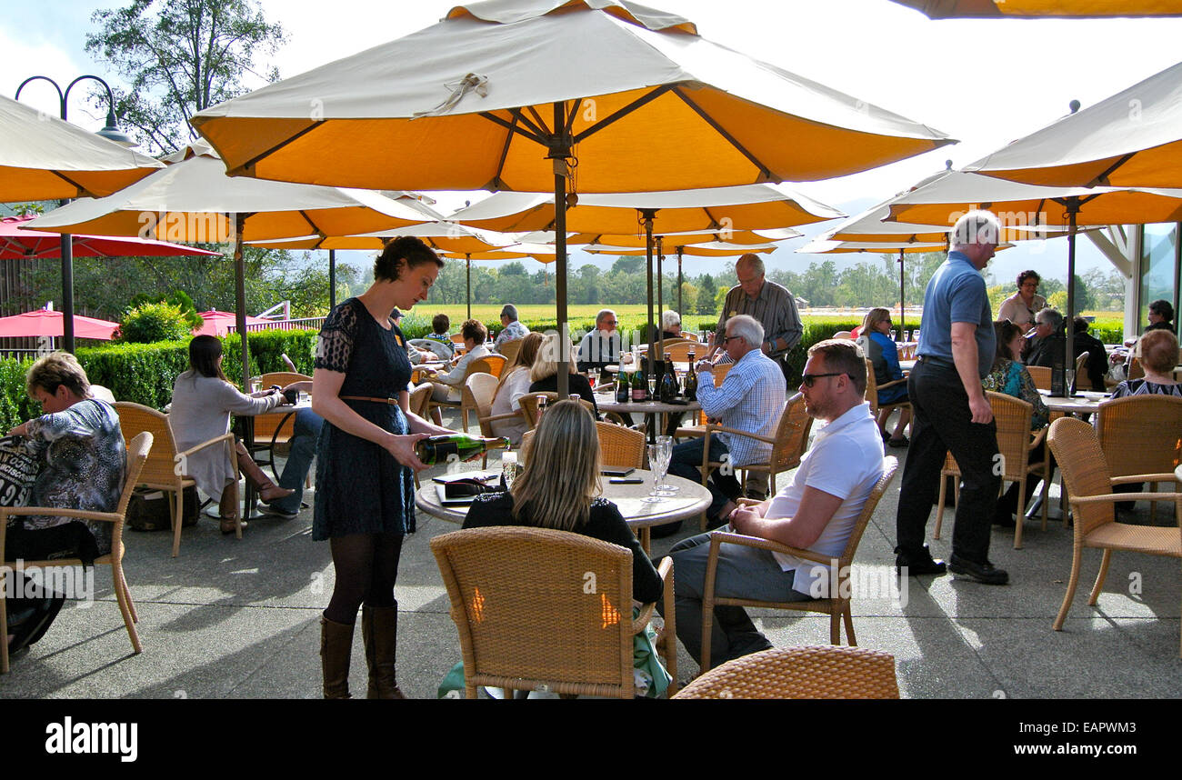 waitress puring wine sampler on the patio of Mumm Napa winery in Rutherford California Stock Photo
