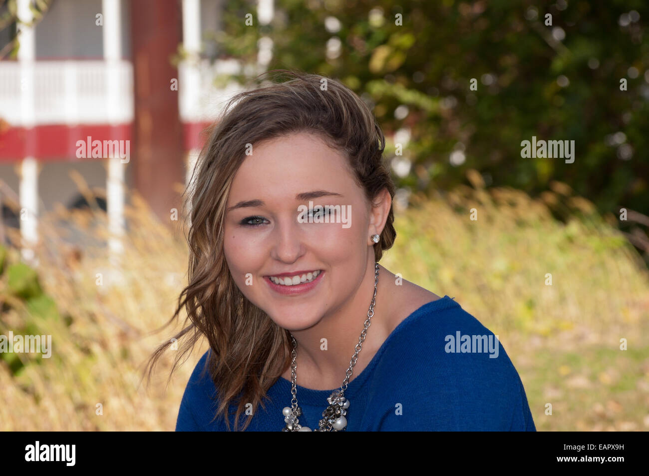 Head and shoulders horizontal portrait of young teen female outdoors smiling Stock Photo