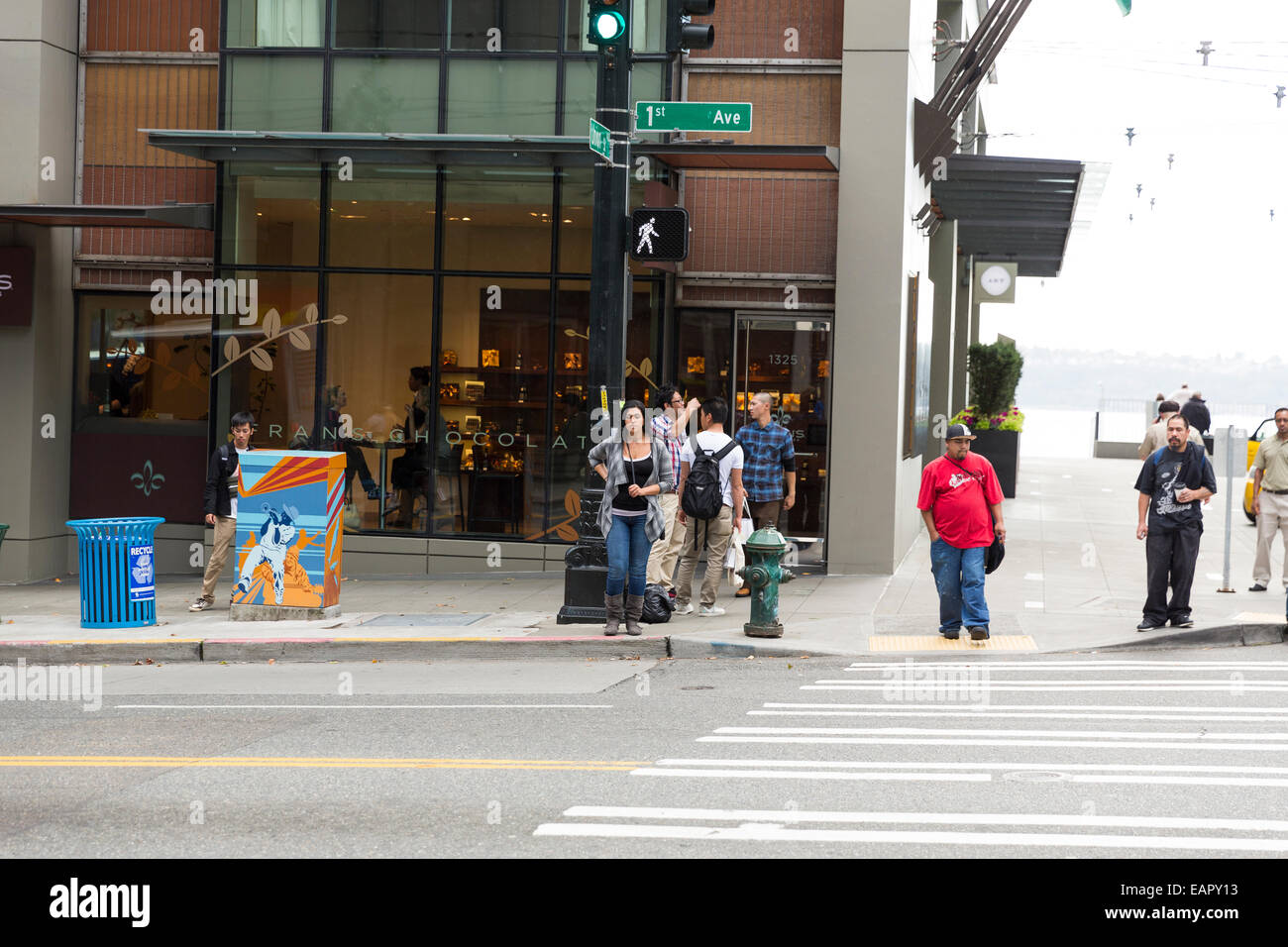 People waiting on a green light to cross a street in Seattle, Washington Stock Photo