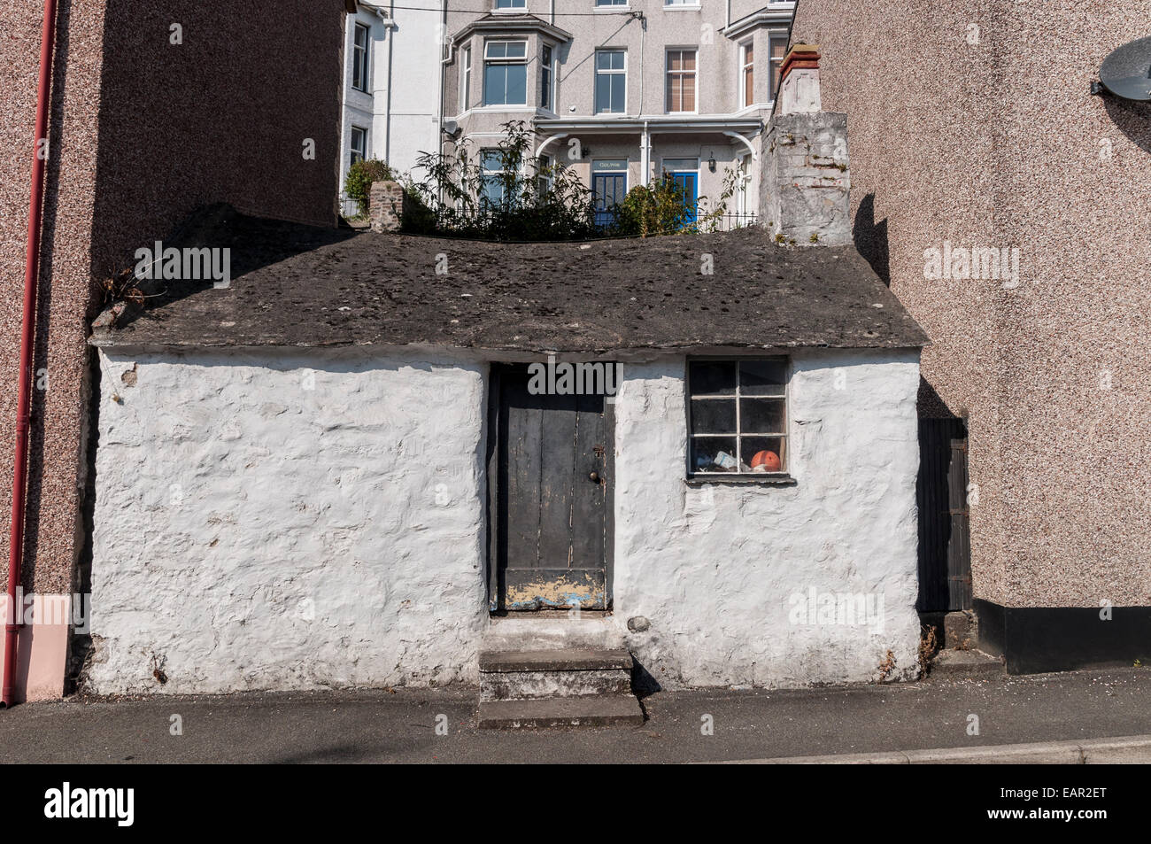Single storey cottage set between two storeyed houses on the west side of Beach Road, below the Cambria in Menai Bridge Anglesey Stock Photo