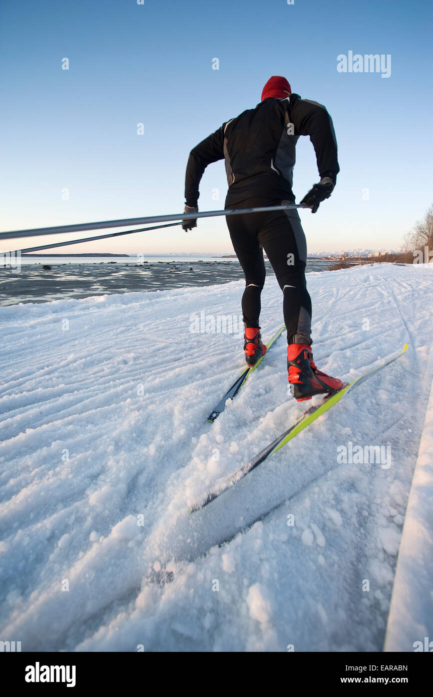 Man And Woman Couple Nordic Skate Skiing At Sunset Along The Tony Knowles Coastal Trail