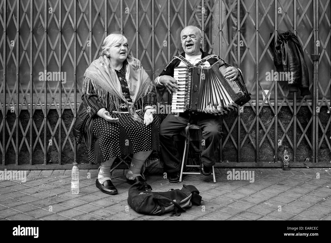 Couple of old people singing and playing on the road for money in Madrid Stock Photo