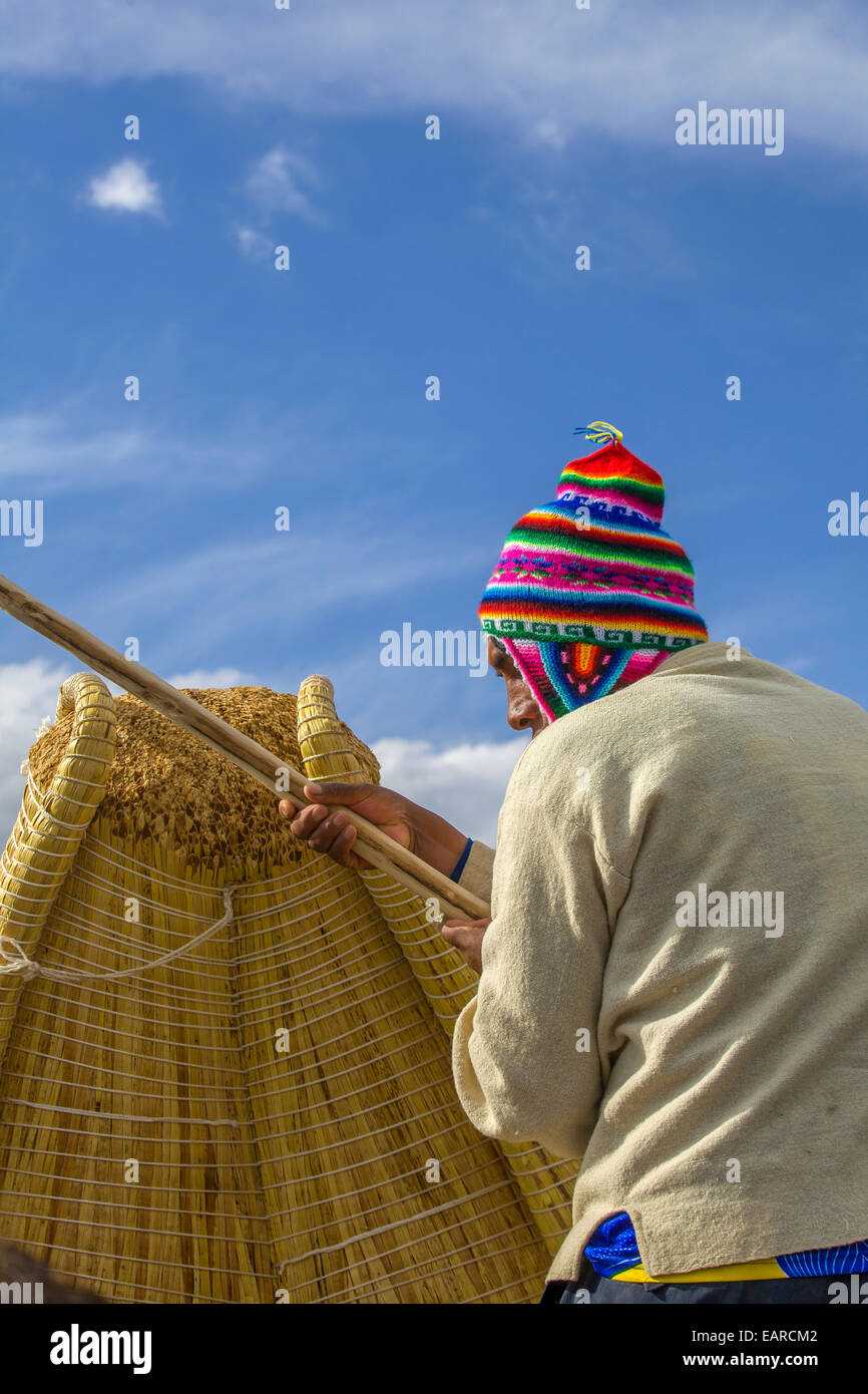 Unidentified  man on a reed boat near a reed island Uros in Lake Titicaca. Stock Photo