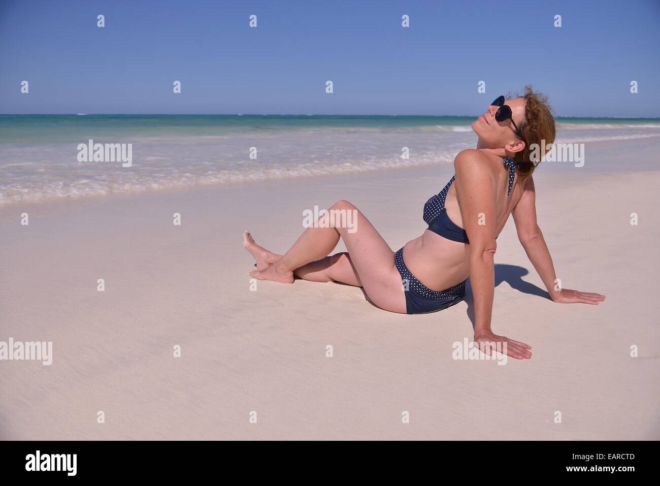 Woman sunbathing at the beach, Dongwe Beach, Dongwe, Zanzibar, Tanzania Stock Photo