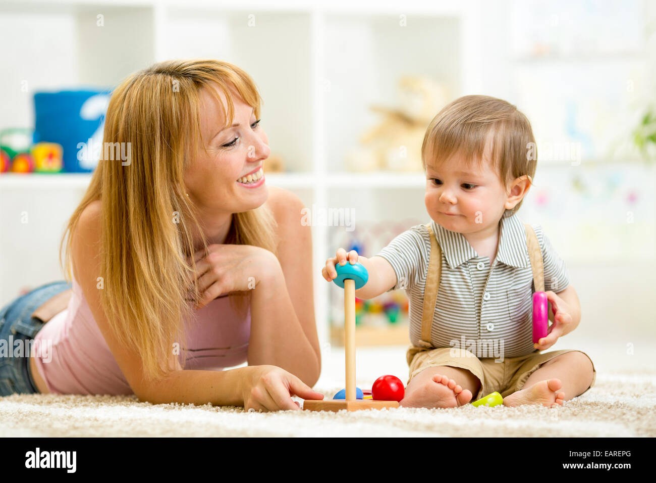 cute woman and kid playing together indoor Stock Photo