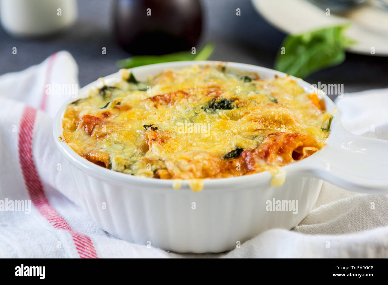 Baked Rigatoni with spinach in tomato sauce Stock Photo