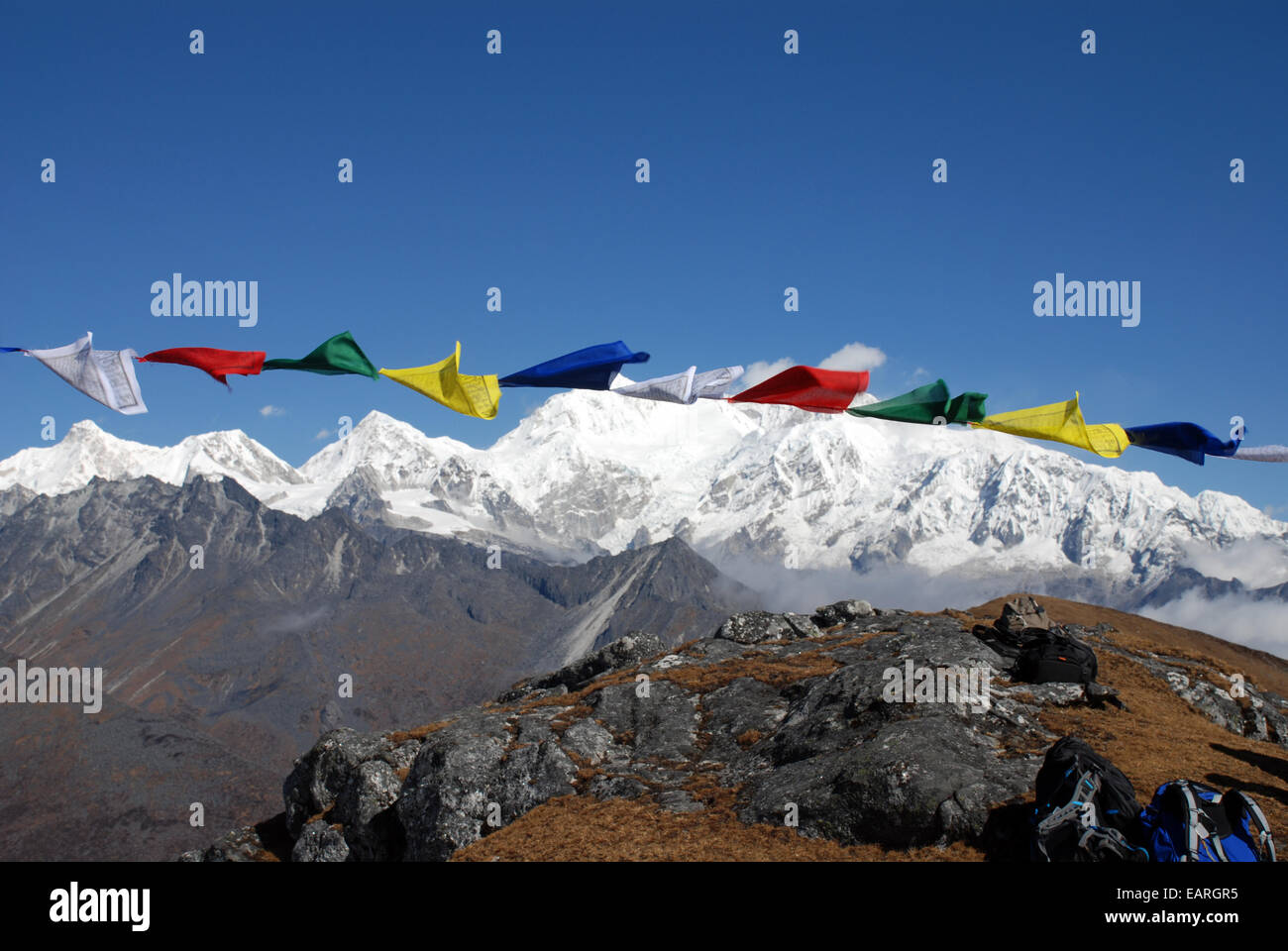 Kangchenjunga is framed by Buddhist prayer flags in this view taken from a high point on the Singalila ridge in India Stock Photo