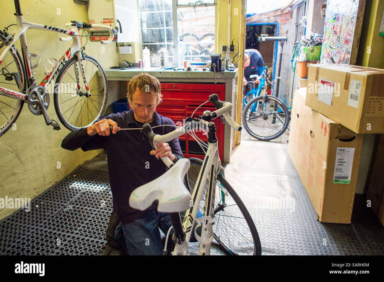 A worker adjusting repairing mending bike at Summit Cycles, small independent bicycle sales and repair centre Aberystwyth UK Stock Photo