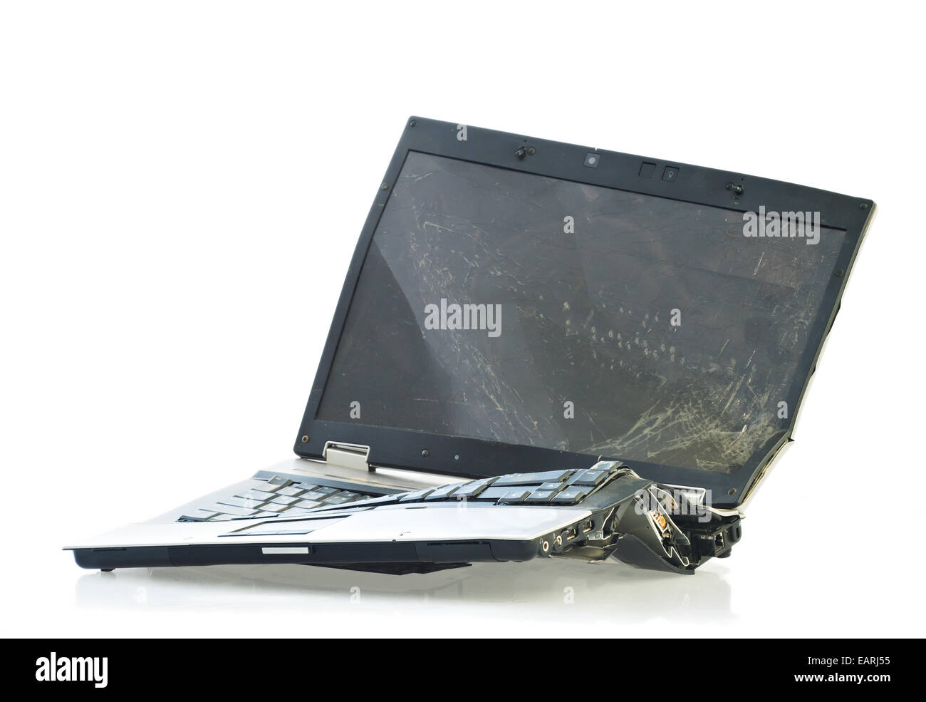Laptop computer destroyed beyond repair in a car accident. Isolated on white background Stock Photo
