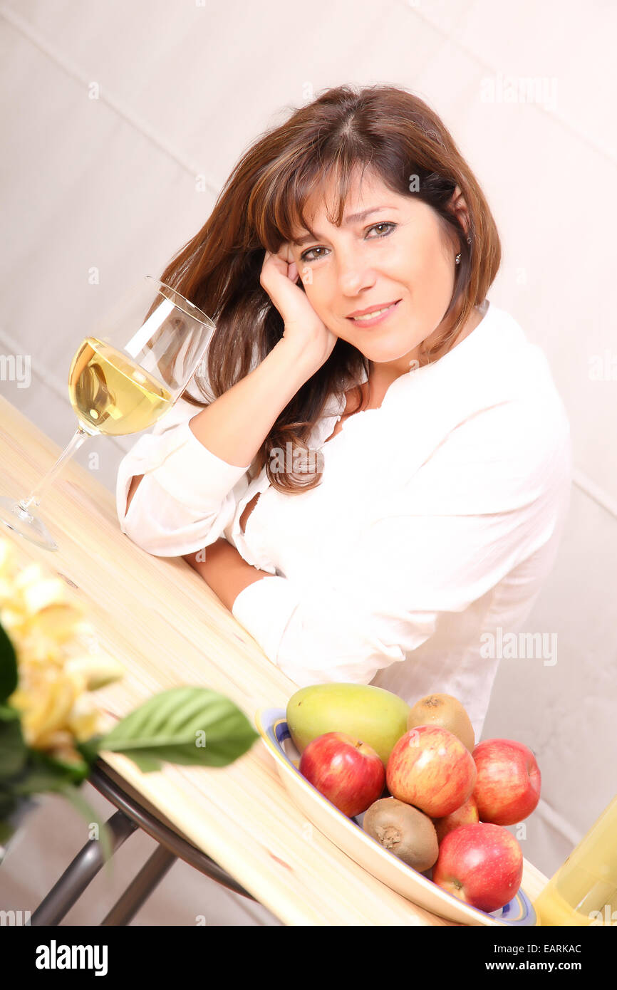 A beautiful mature woman with a glass of white wine Stock Photo - Alamy