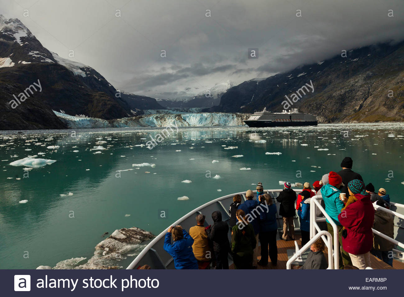 Tourists watch a glacier from a boat. Stock Photo