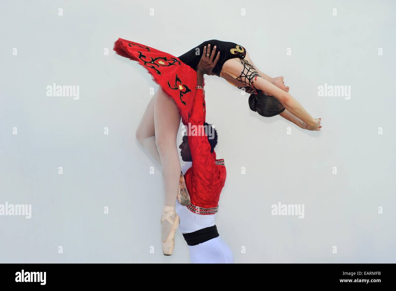 A ballet dancer holds his partner up in the air. Stock Photo