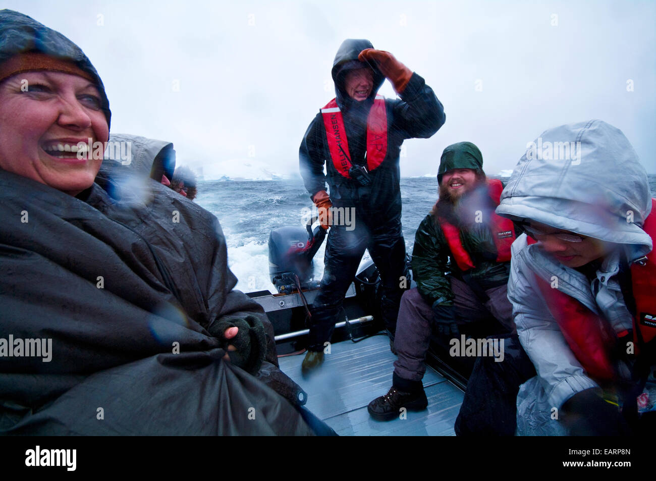 Tourists enjoy wild weather and rough seas in a zodiac in Antarctica. Stock Photo