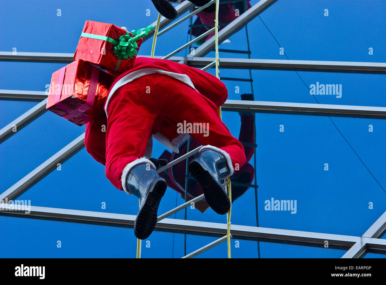 A Santa Claus mannequin climbing the outside of a shopping mall Stock ...