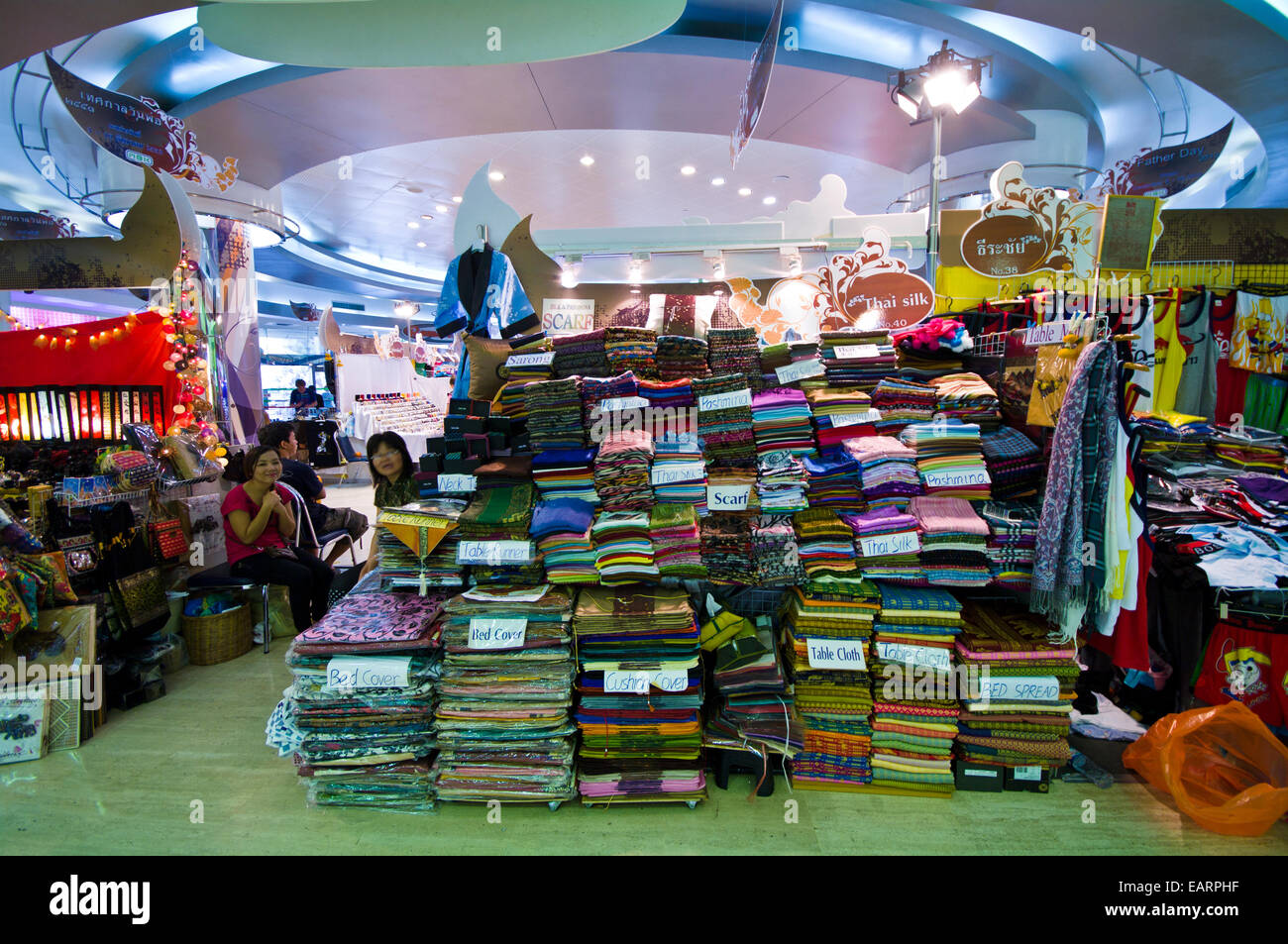 A temporary stall in a shopping mall sells discounted silk pashminas. Stock Photo