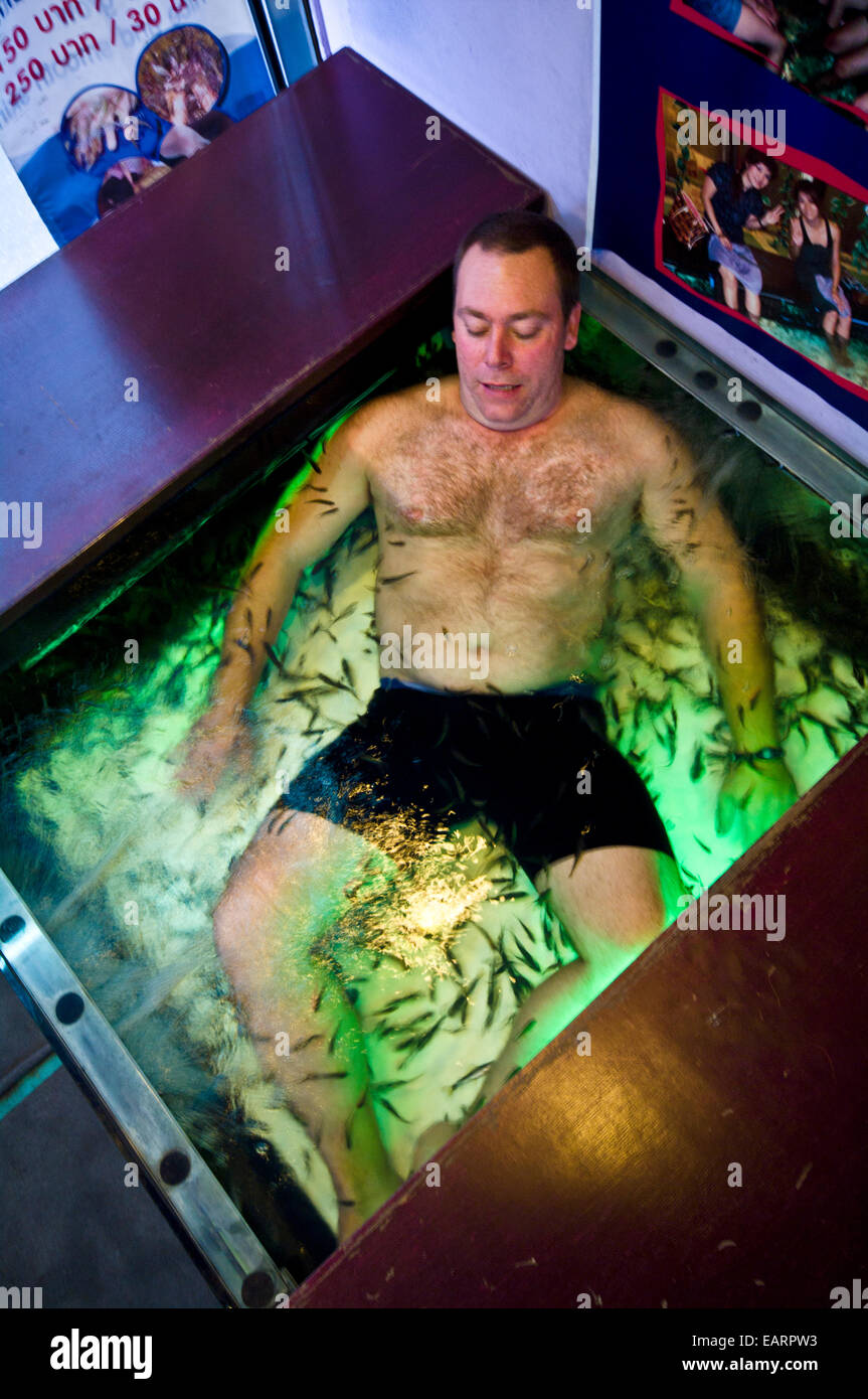 Flesh eating fish devour dead skin cells from a fish spa patrons body. Stock Photo