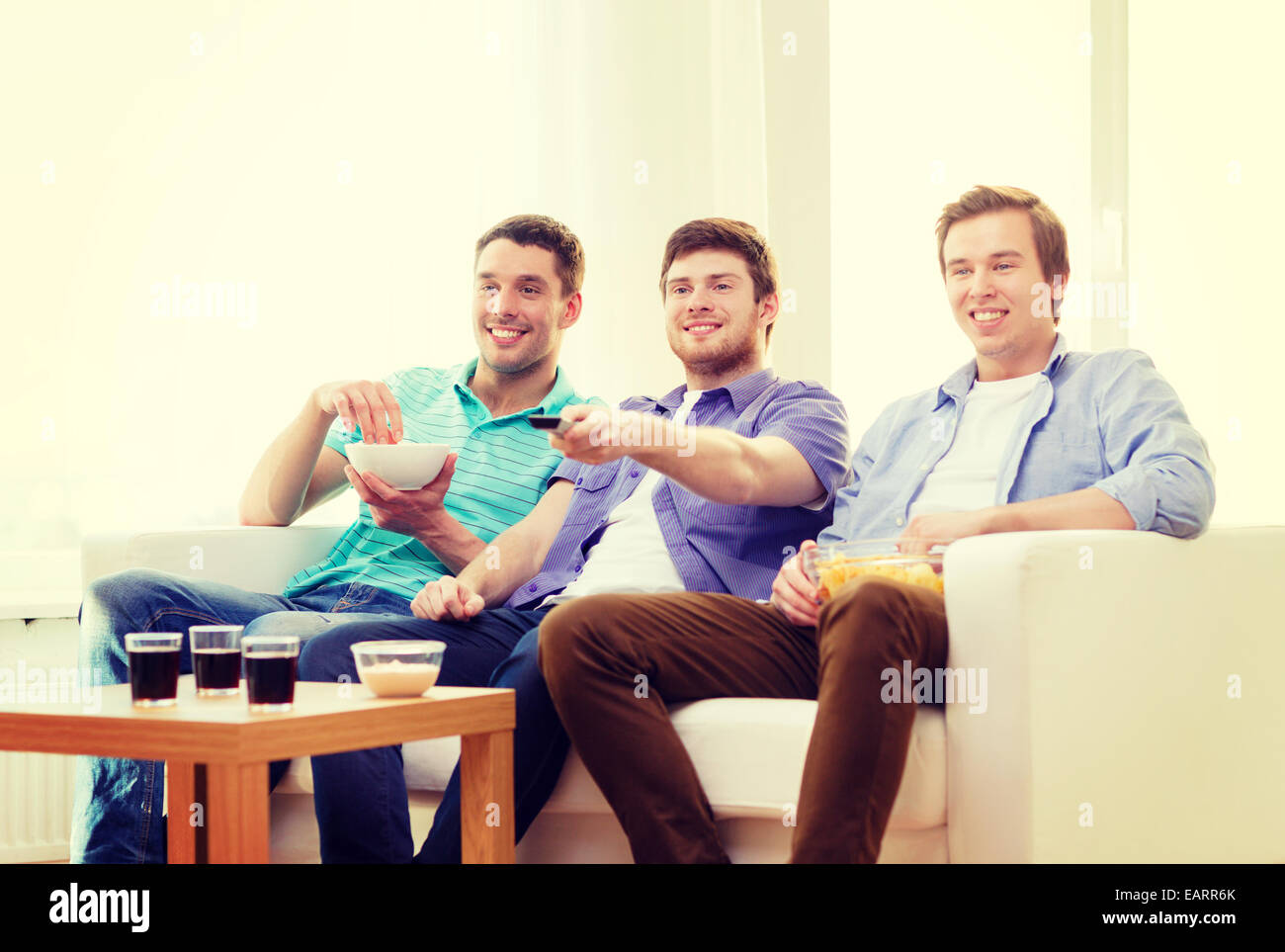 smiling friends with remote control at home Stock Photo - Alamy