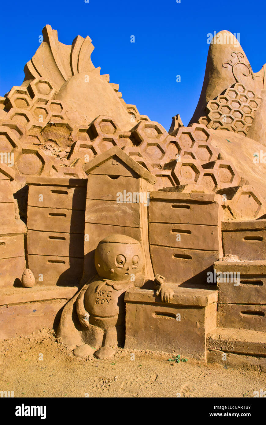 A professional sand sculpture features bee hive boxes and honeycomb. Stock Photo