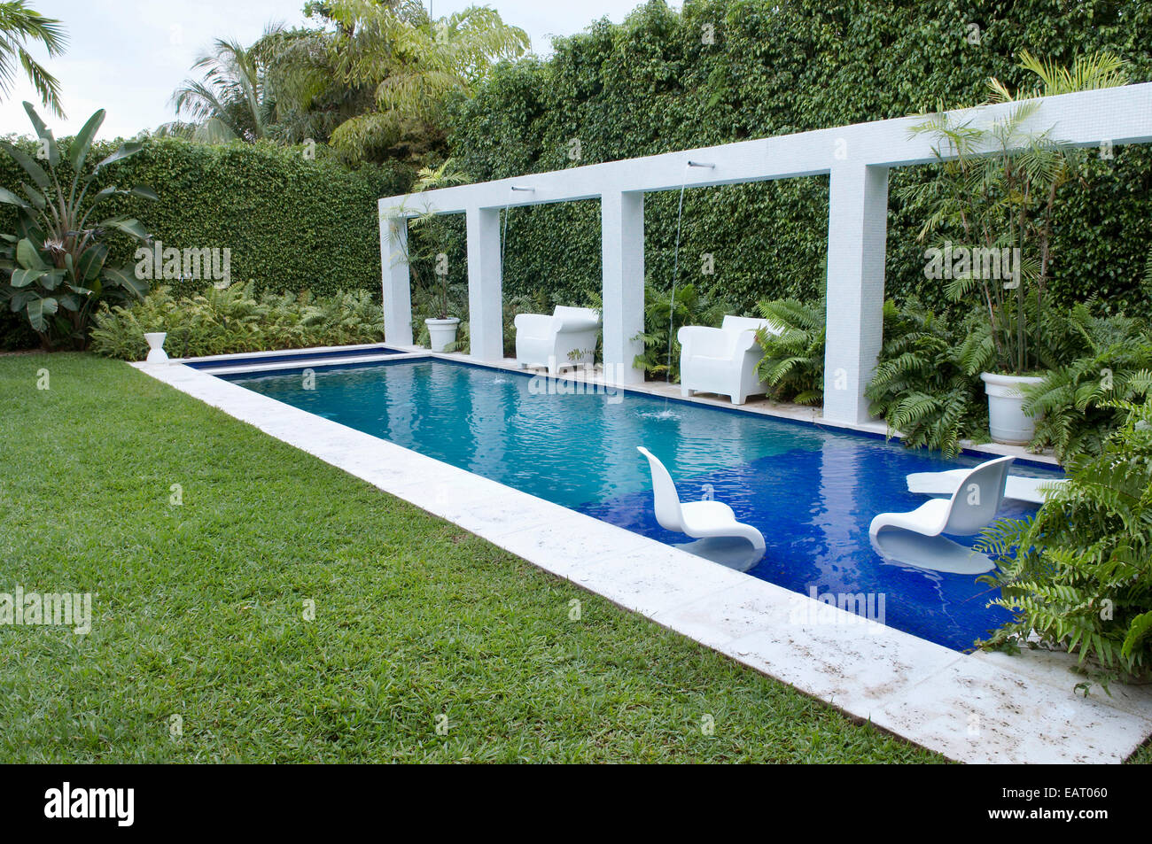 Chairs and sun loungers beside lap pool in garden Stock Photo Alamy