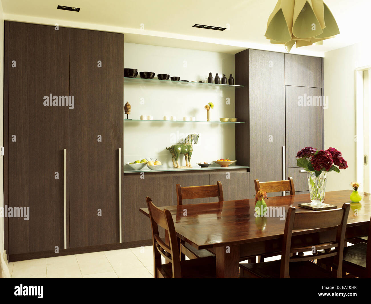 Dining table and chairs in front of central island unit in spacious