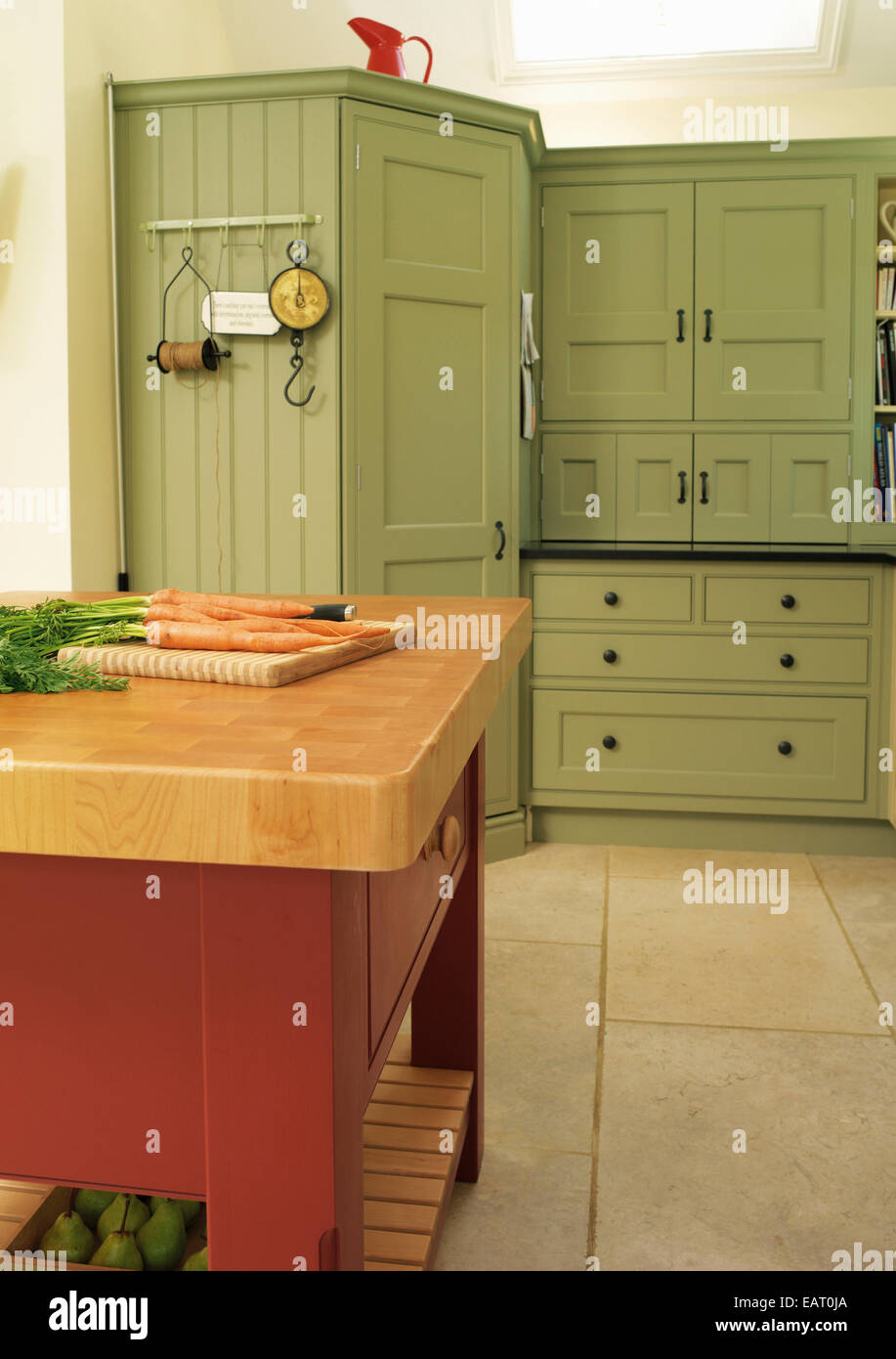 Freestanding worktop unit in centre of country style green kitchen