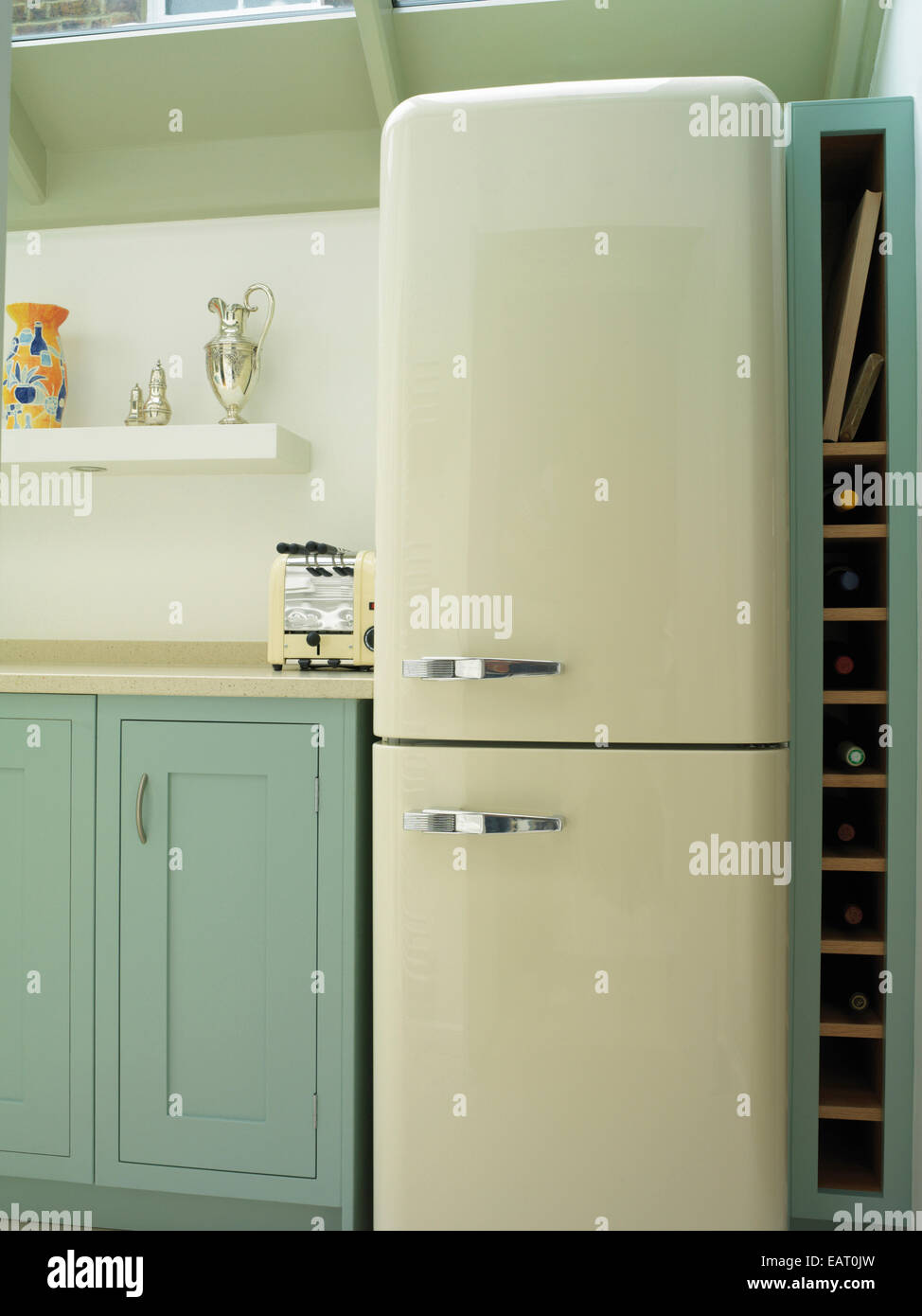 Fridge next to blue units in contemporary kitchen Stock Photo Alamy