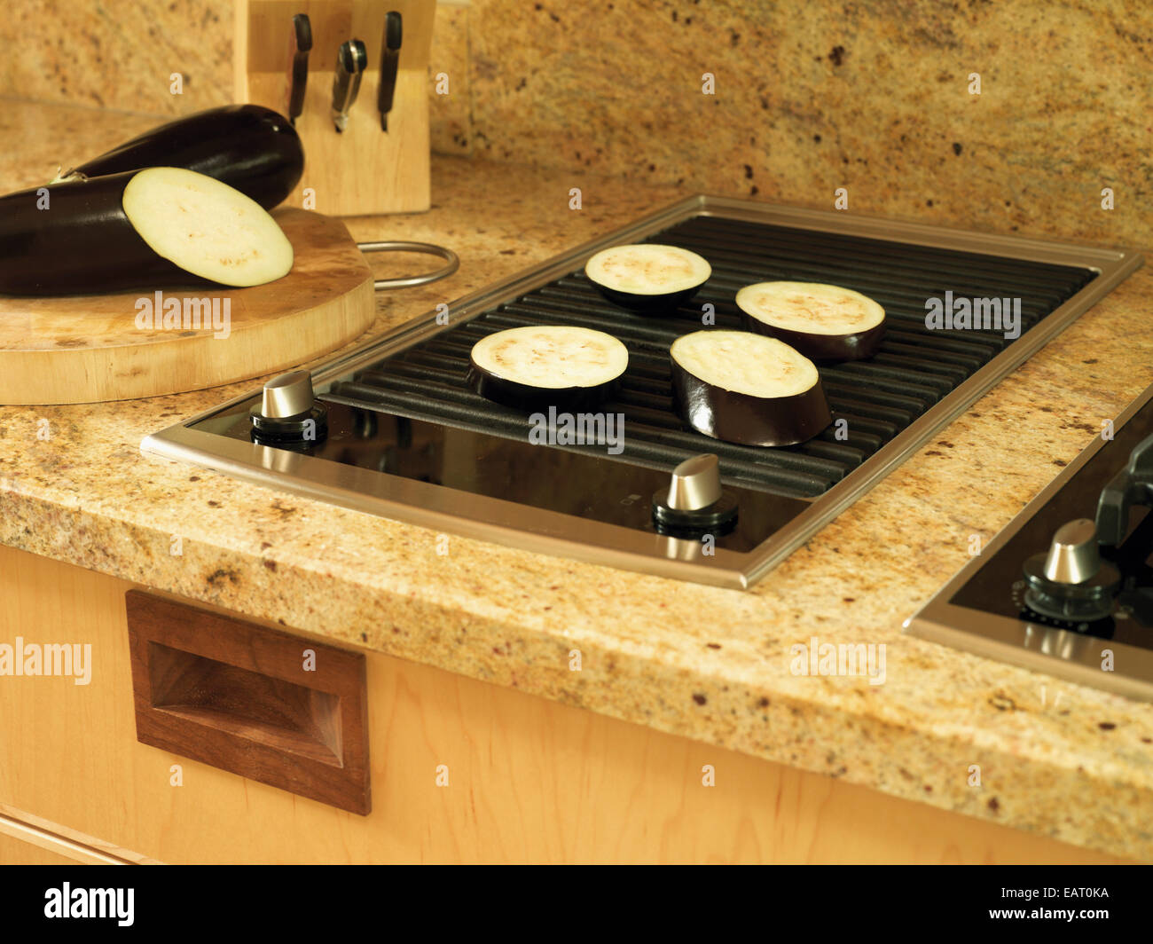 Aubergine frying on griddle in contemporary kitchen Stock Photo - Alamy