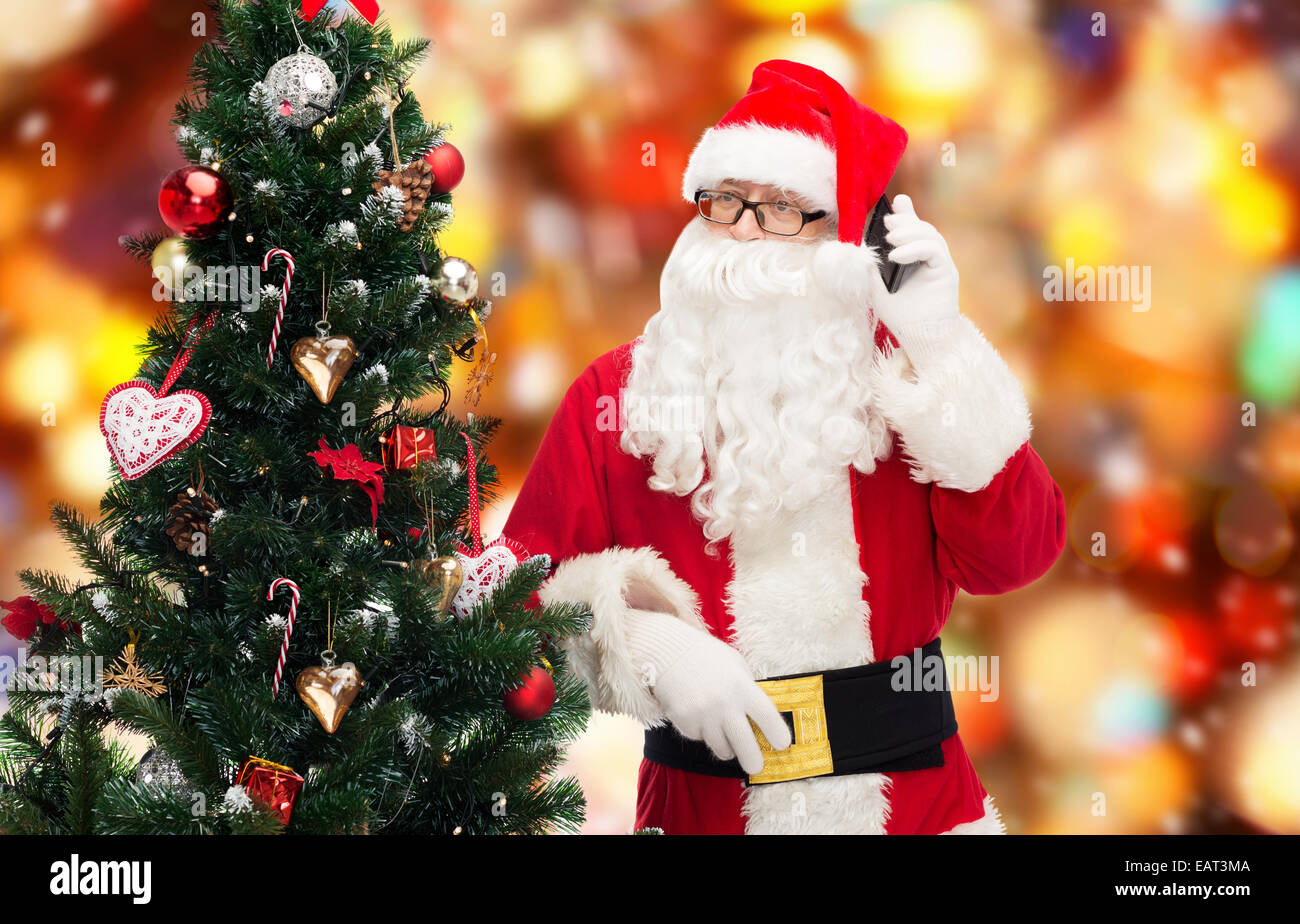santa claus with smartphone and christmas tree Stock Photo - Alamy