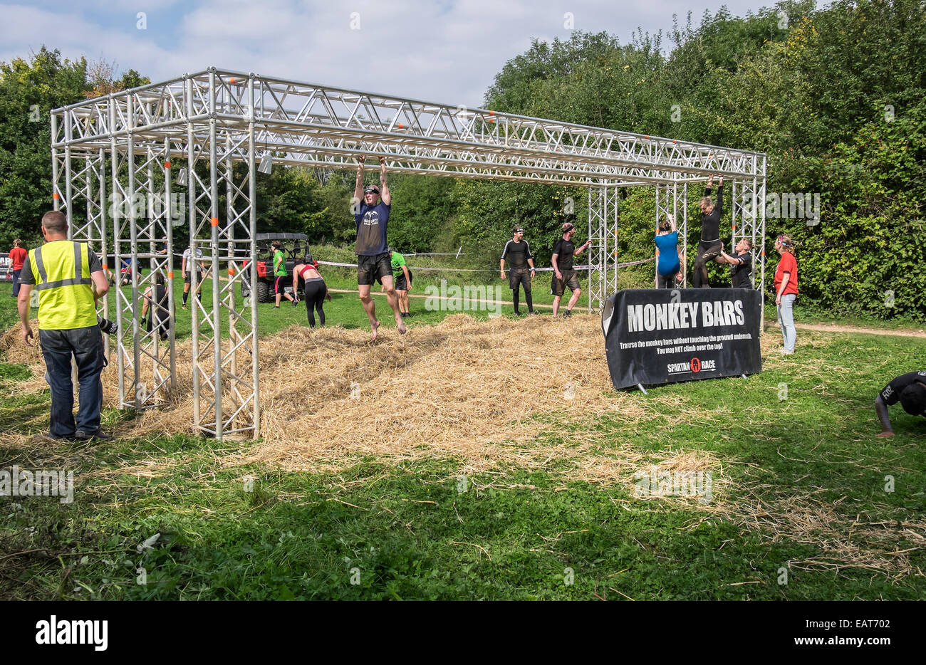 Competitors traversing Monkey bars obstacle Spartan race Milton country park Stock Photo
