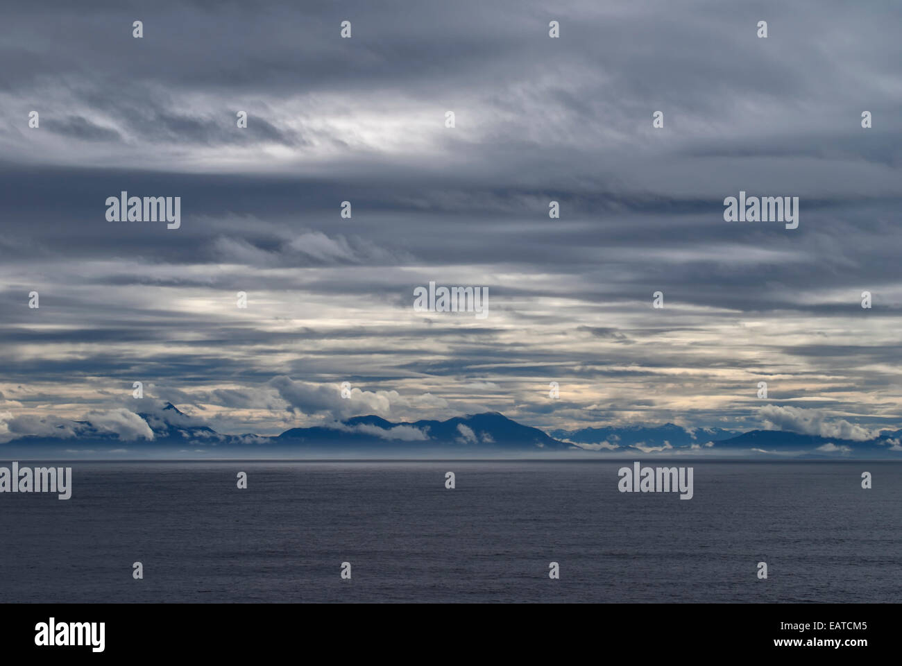Fascinating clouds over Alaska's west coast with a narrow fog band near the beach. Stock Photo