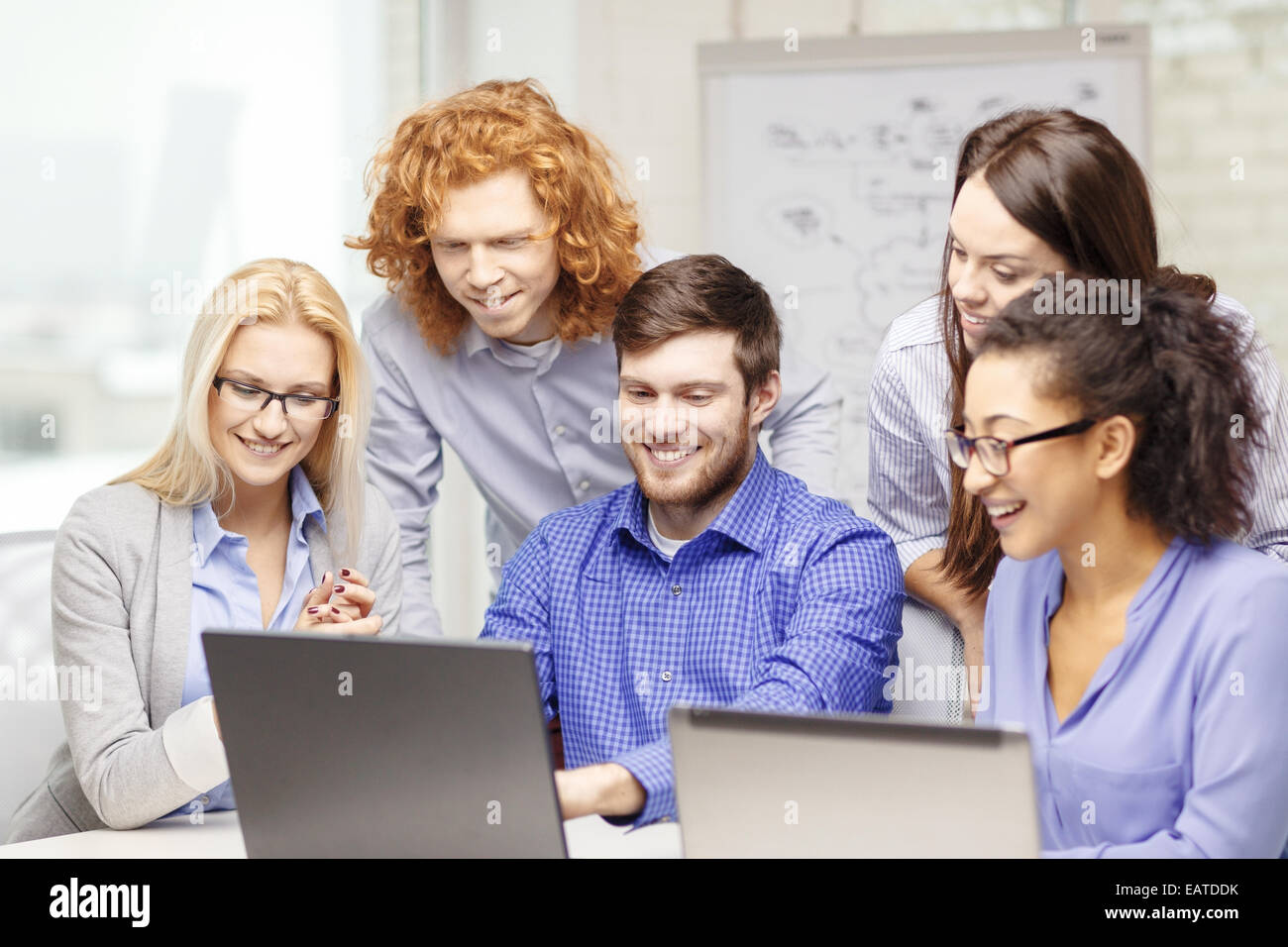 Team Using Computers smiling team with laptop computers in office Stock Photo - Alamy