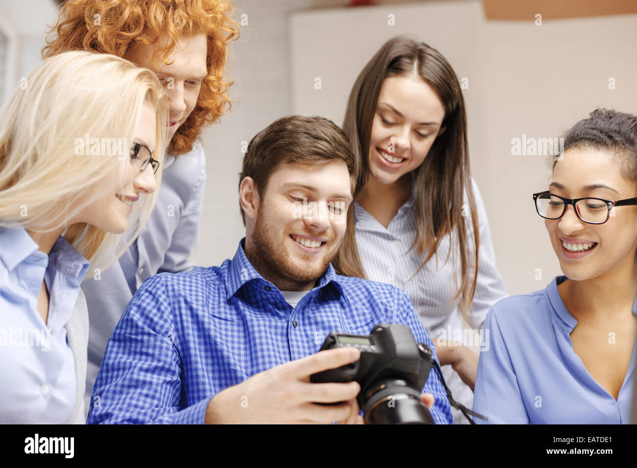 smiling team with photocamera in office Stock Photo - Alamy