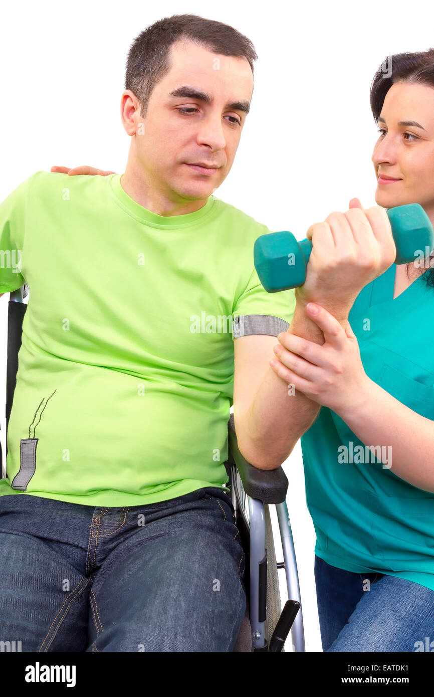 Physical therapist works with patient in lifting hands weights. young adult in wheelchair. Stock Photo