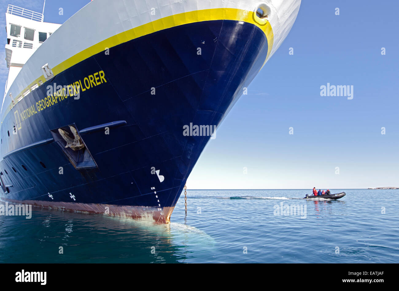 An inflatable boat below the bow of The National Geographic Explorer. Stock Photo