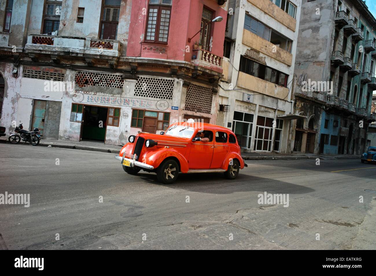 An orange vintage American car in downtown or Centro Havana. Stock Photo
