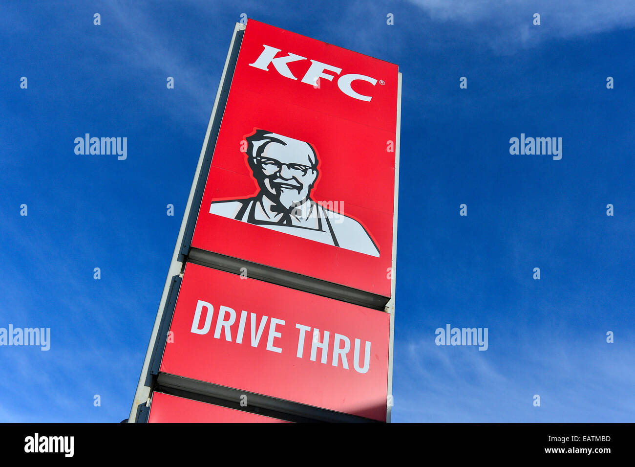 Stock Photo - KFC Kentucky Fried Chicken Drive Thru red sign with Colonel Sanders on roadside with blue sky. Stock Photo