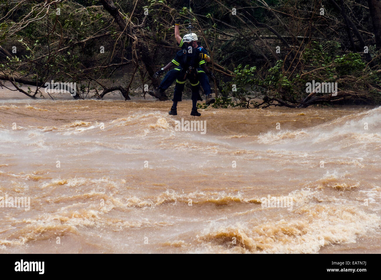 An Airforce and police rescue crew lowered onto a flooded river. Stock Photo