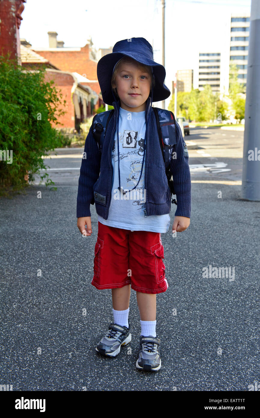 A boy poses for a picture outside his home on his first day of school. Stock Photo