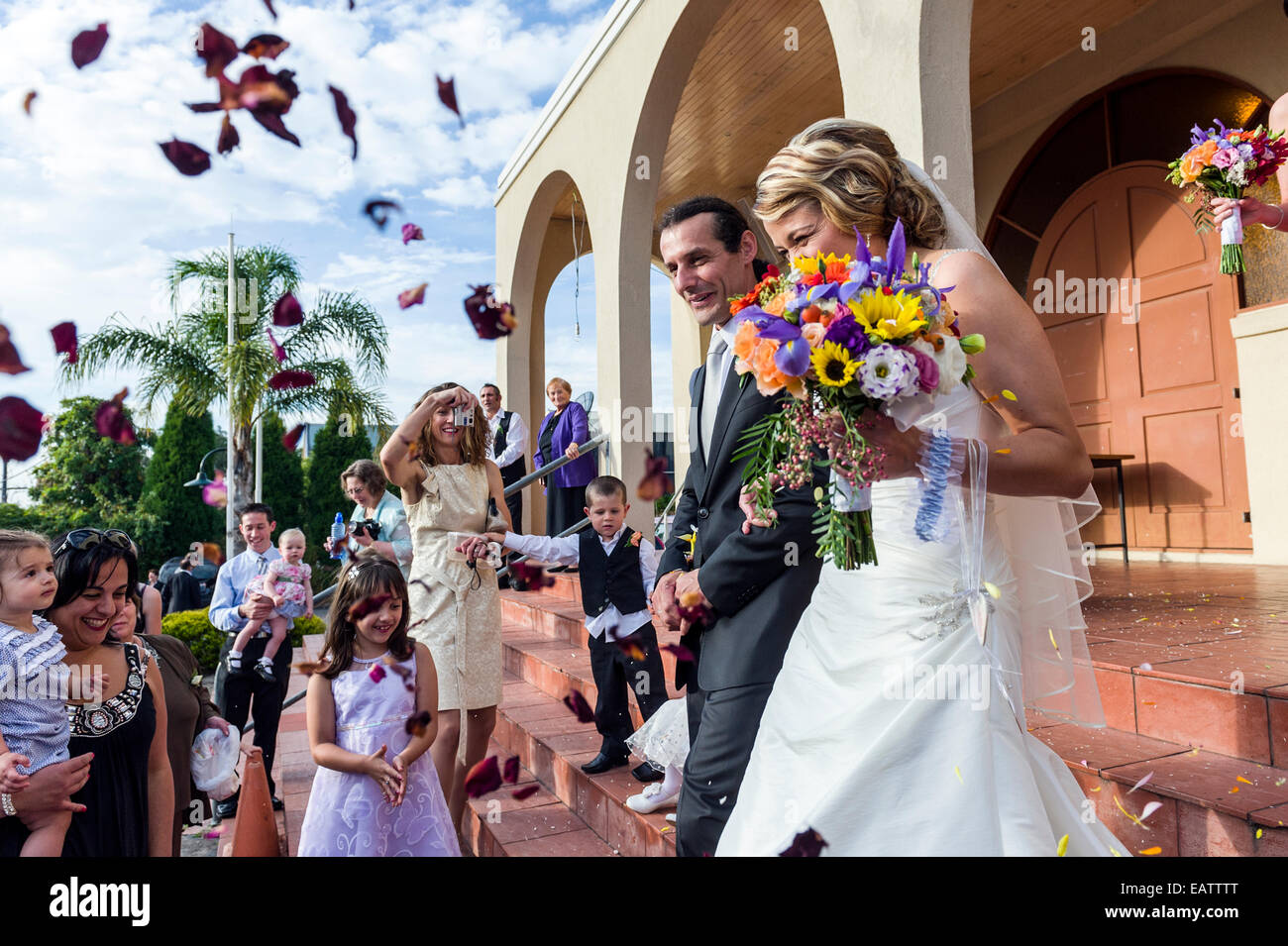 Newlyweds kissing while exiting the church after wedding ceremony, family  and friends celebrating their love with the shower of soap bubbles, custom  Stock Photo - Alamy