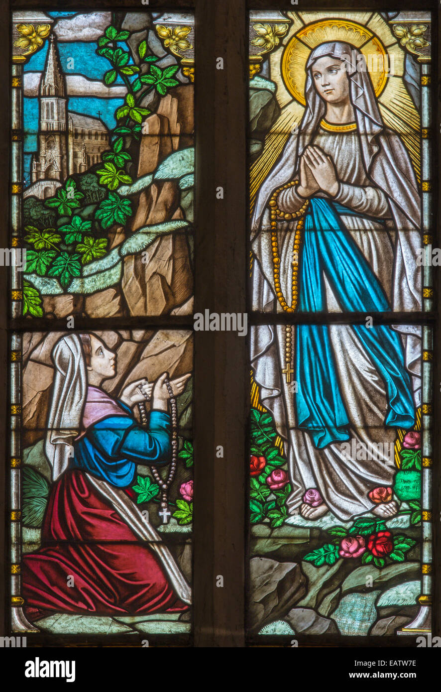 Trnava - The Virgin Mary of Loures and st. Bernadette Soubirous windowpane in St. Nicholas church and Virgin Mary chapel. Stock Photo