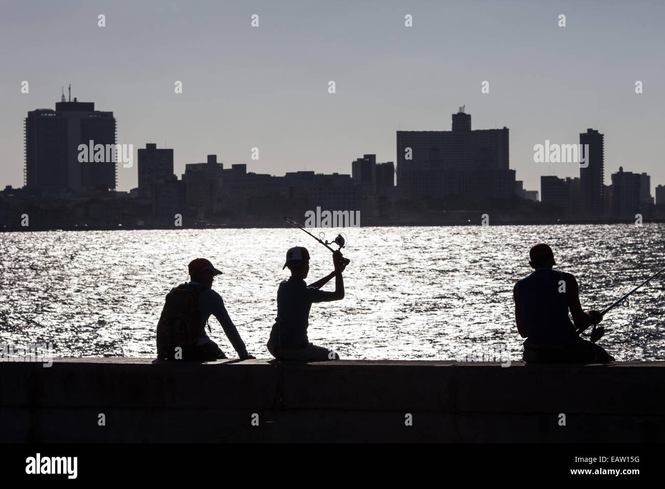 Silhouette of locals fishing on the Malecon seafront Stock Photo