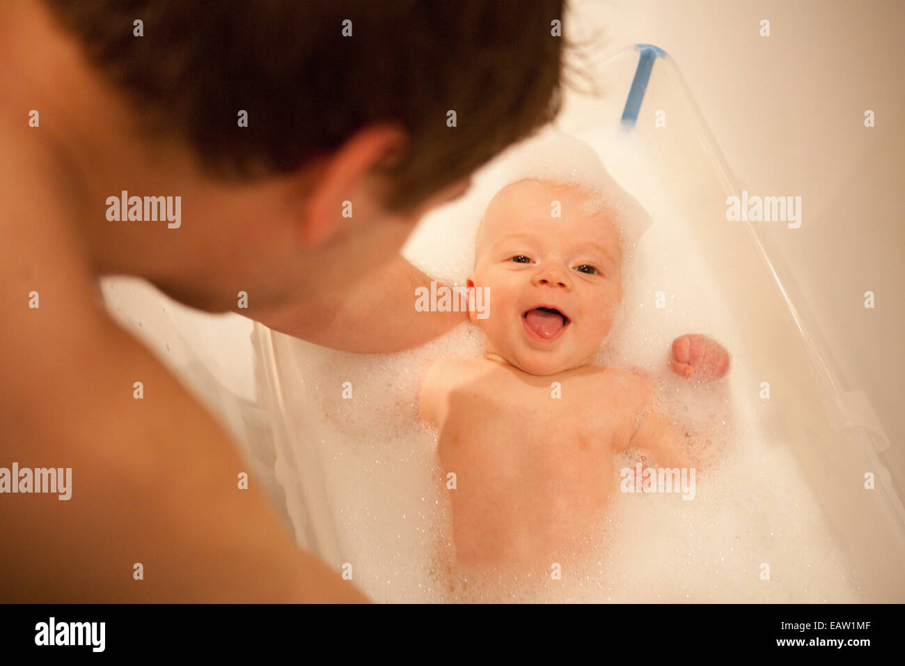 Baby enjoying a bath with father Stock Photo Alamy