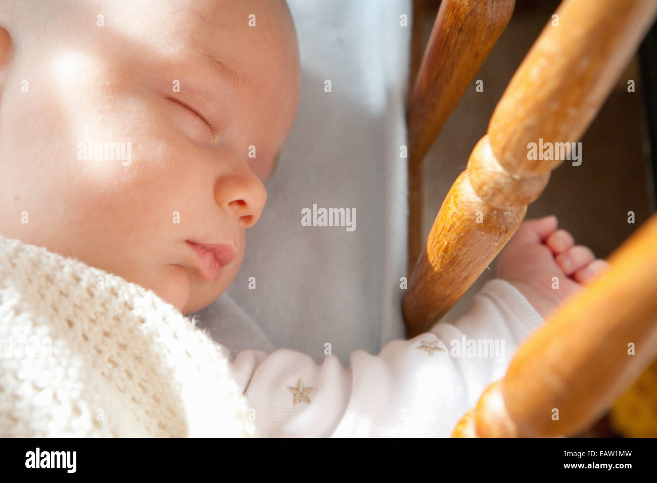 Baby boy sleeping with hand hanging out of cot Stock Photo Alamy