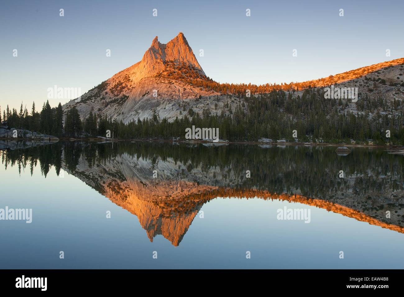 Sunset with Cathedral Peak reflecting in Upper Cathedral Lake in Yosemite National Park Stock Photo