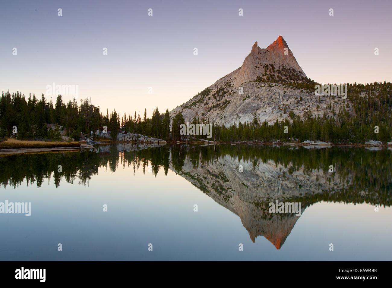 Sunset with Cathedral Peak reflecting in Upper Cathedral Lake in Yosemite National Park Stock Photo