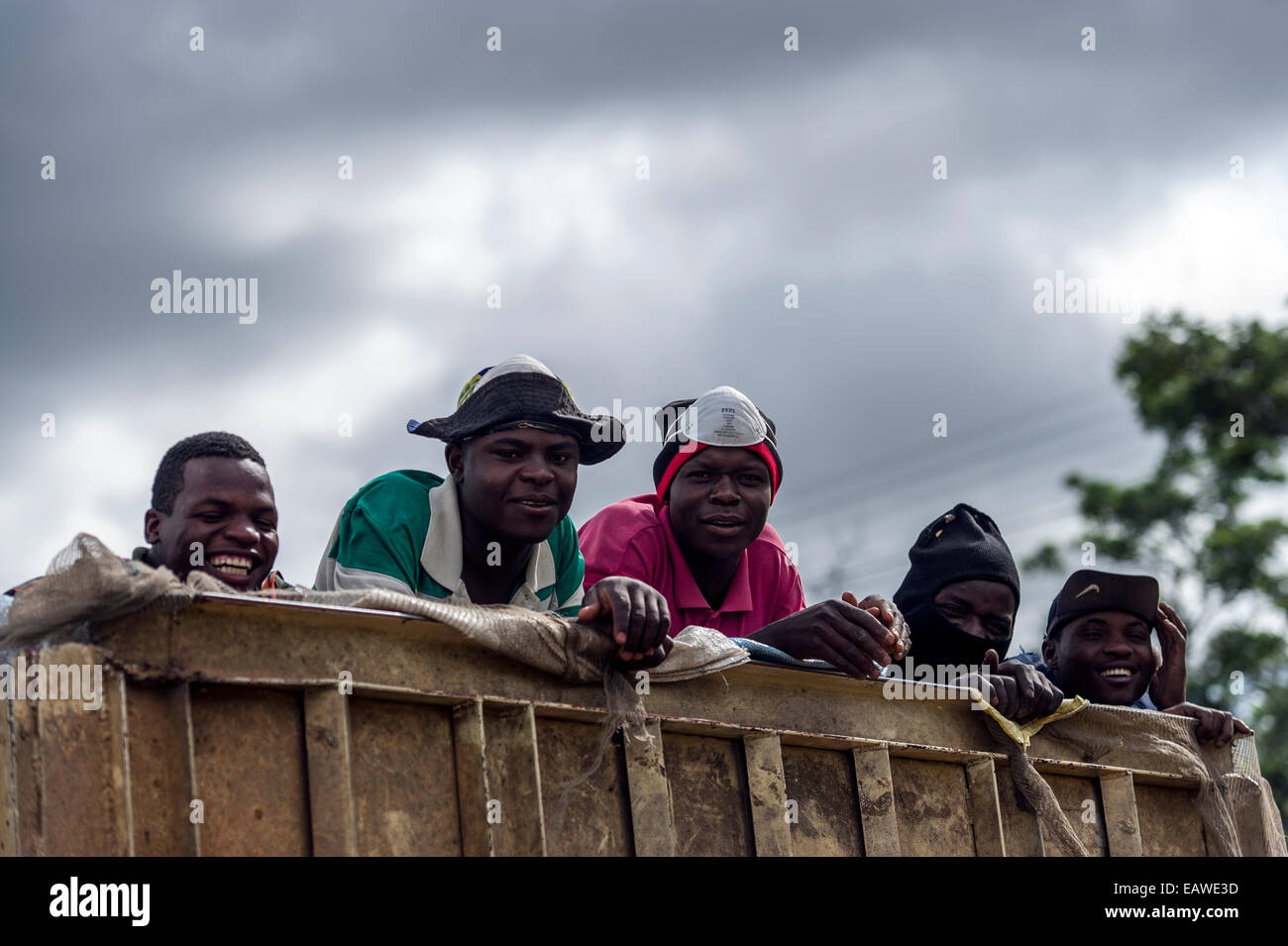 Laborers travel in the back of a truck on their way to the next job. Stock Photo