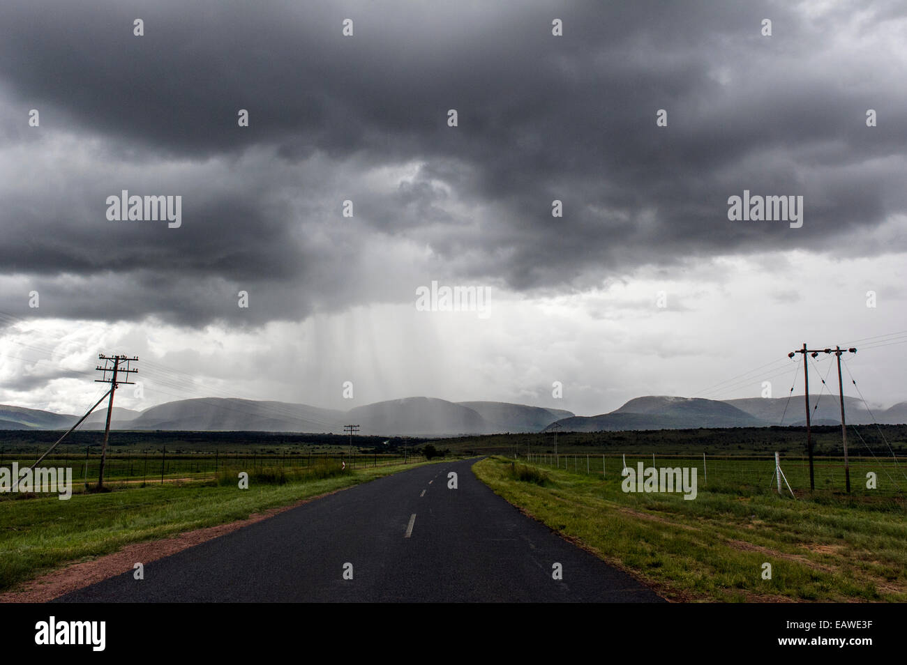 A torrential rainstorm descends on a remote country road and farmland. Stock Photo